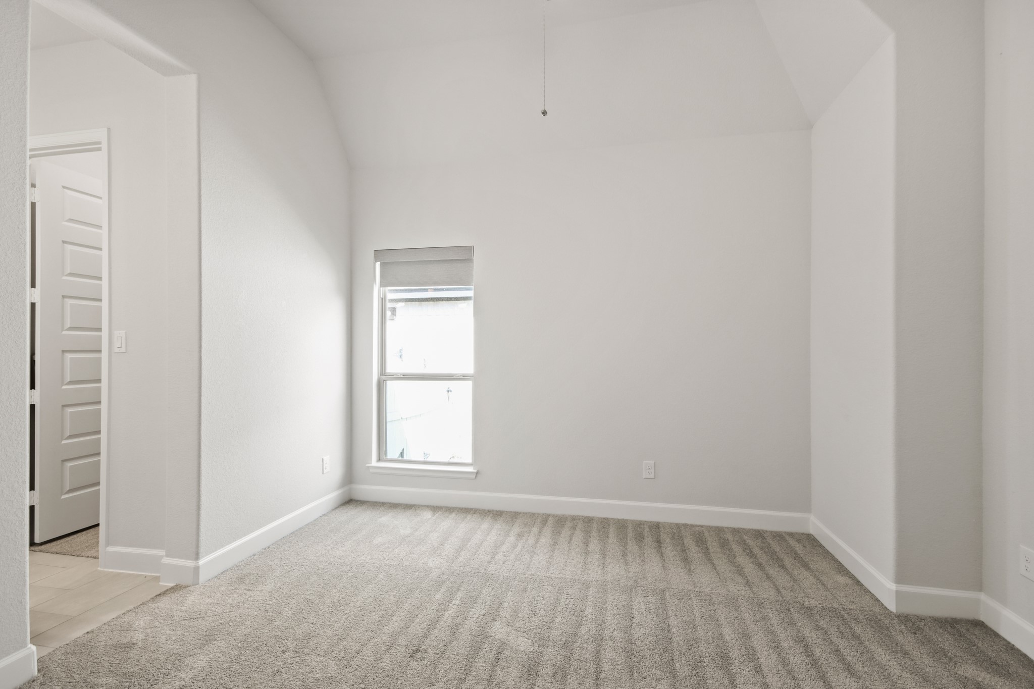 17406 Bayflower Conroe, TX 77385 - Photo 29 of 35 Secondary bedroom features neutral walls and carpet, a vaulted ceiling, and a window that provides natural light.