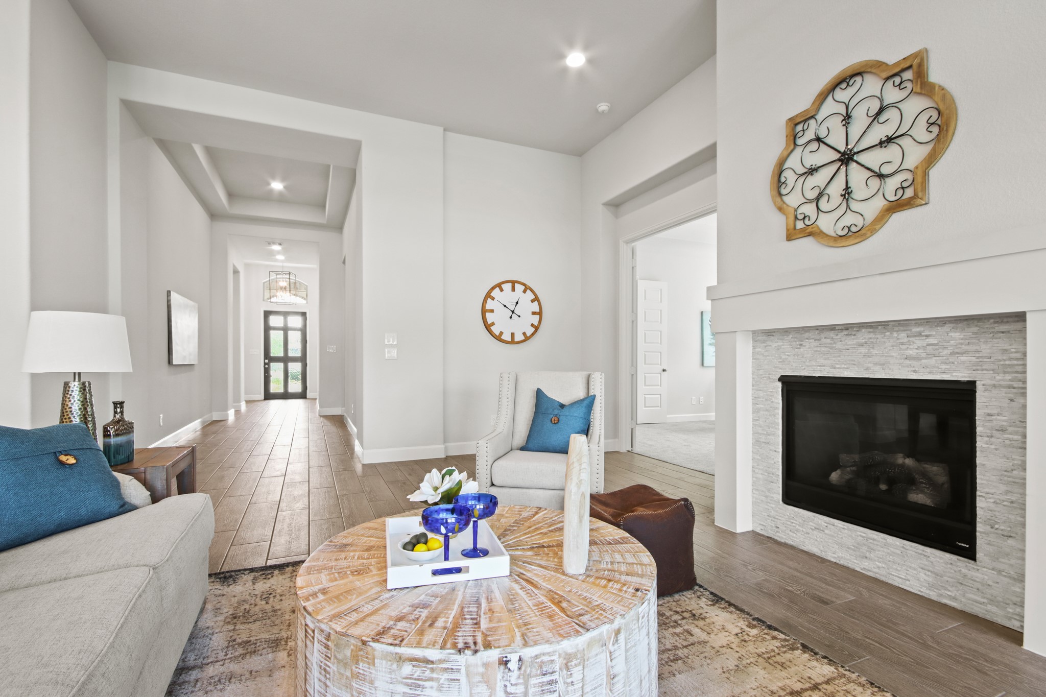 17406 Bayflower Conroe, TX 77385 - Photo 5 of 35 Bright and inviting living area with a modern fireplace and open layout with wood styled tile flooring and ample natural light, creating a warm and welcoming atmosphere.