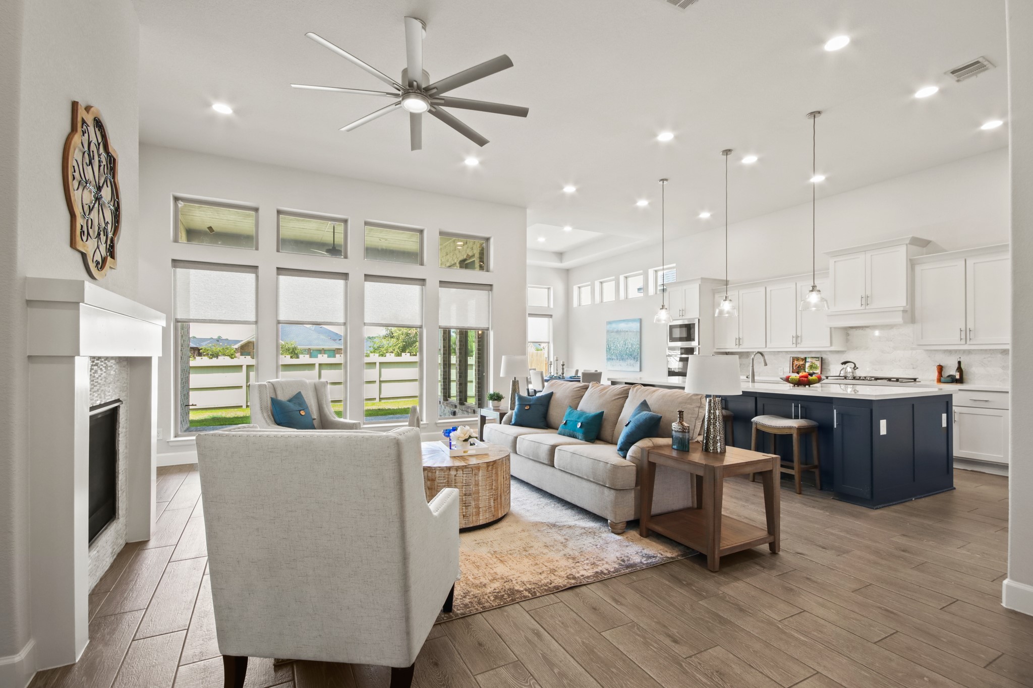 17406 Bayflower Conroe, TX 77385 - Photo 6 of 35 This spacious open-concept living area features modern design with a cozy fireplace, large windows for natural light, and a stylish kitchen with a breakfast bar. Perfect for entertaining and family gatherings.