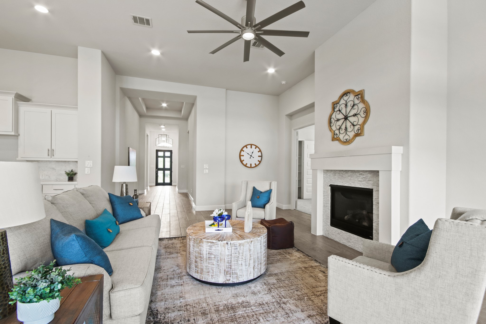 17406 Bayflower Conroe, TX 77385 - Photo 8 of 35 Bright and spacious living room with fireplace, neutral tones, and wood-styled tile flooring. High ceilings and ample natural light enhance the welcoming atmosphere.