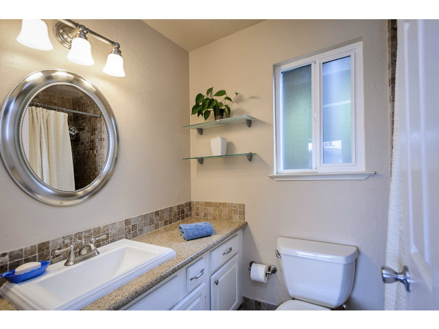 508 Monterey Road, Unit E Pacifica, CA 94044 - Photo 13 of 17 a bathroom with a sink a mirror and a toilet