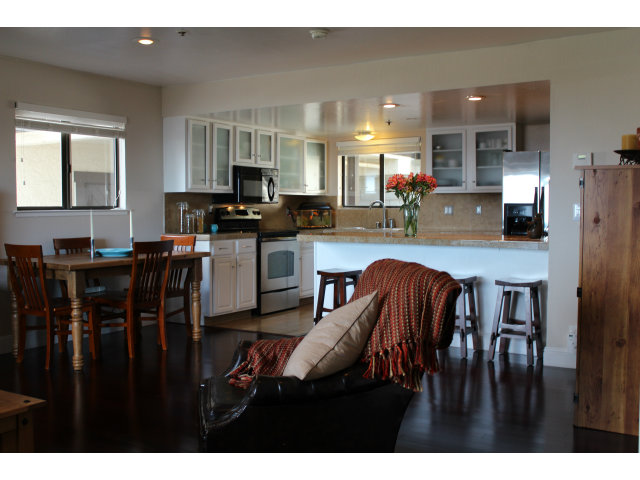 508 Monterey Road, Unit E Pacifica, CA 94044 - Photo 6 of 17 a kitchen with stainless steel appliances wooden floor dining table and chairs