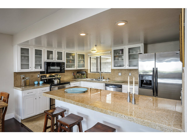 508 Monterey Road, Unit E Pacifica, CA 94044 - Photo 9 of 17 a kitchen with stainless steel appliances kitchen island granite countertop a refrigerator and cabinets