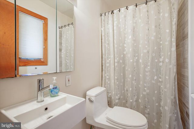 a bathroom with a sink a toilet and a mirror