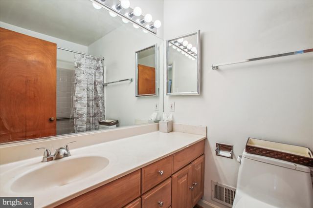 a bathroom with a sink a toilet a mirror and shower