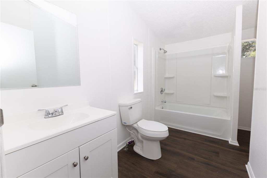 4872 Evans Street Coleman, FL 33521 - Photo 11 of 24 a bathroom with a sink toilet a mirror and bathtub