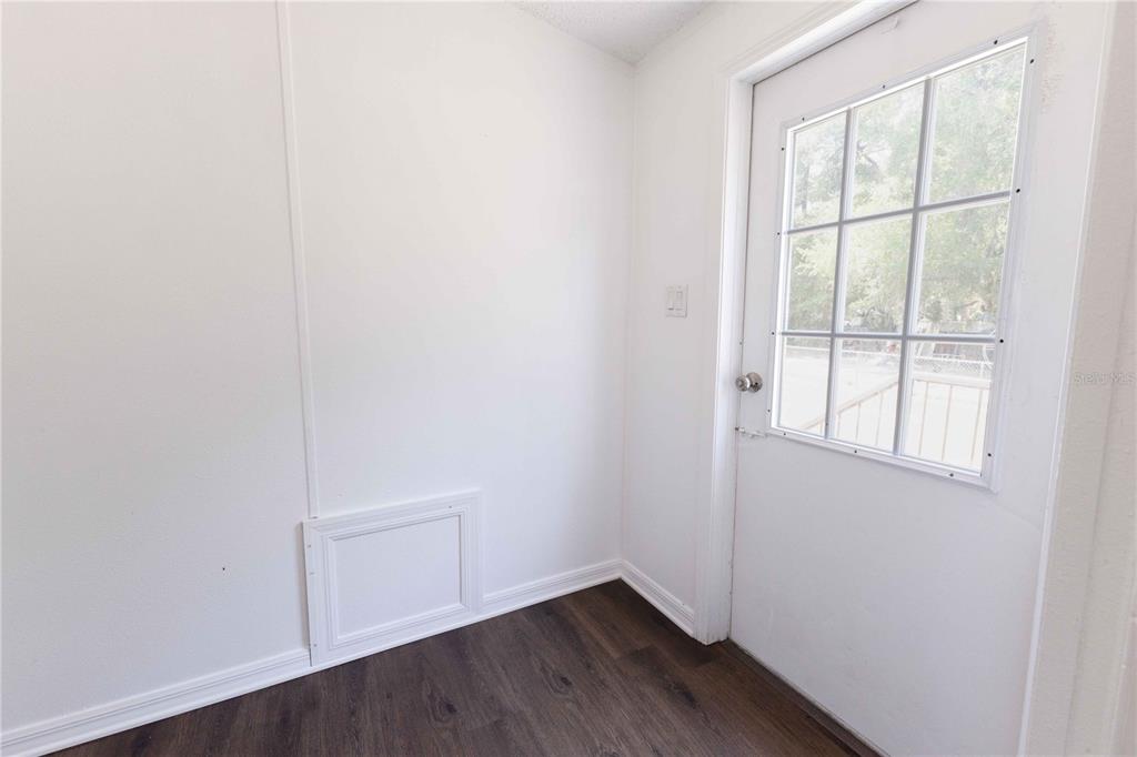 4872 Evans Street Coleman, FL 33521 - Photo 21 of 24 an empty room with wooden floor and windows