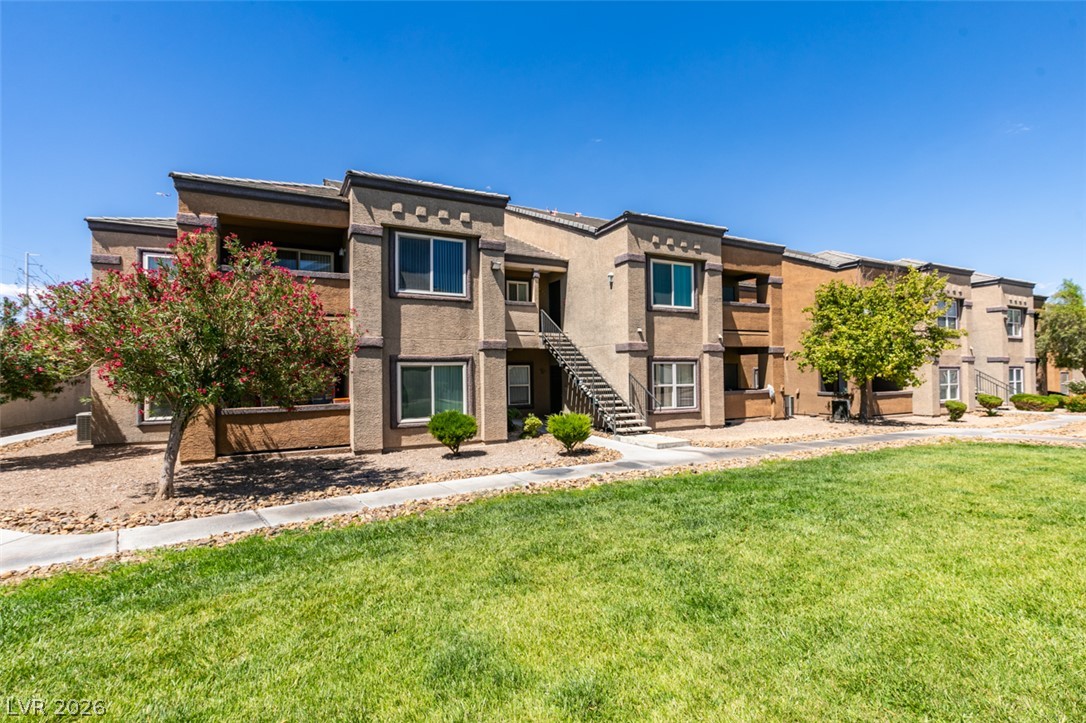 6650 West Warm Springs Road, Unit 2118 Las Vegas, NV 89118 - Photo 30 of 41 A striking multi-story apartment complex offers a blend of contemporary design and lush green surroundings.