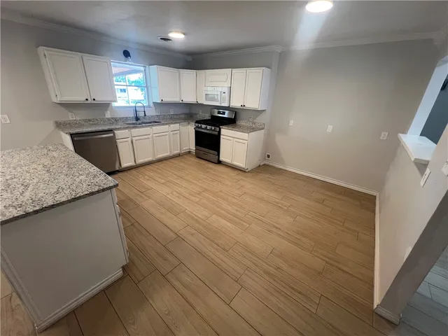 a kitchen with granite countertop a sink and cabinets