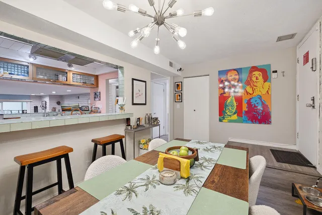 a living room with furniture kitchen view and a chandelier