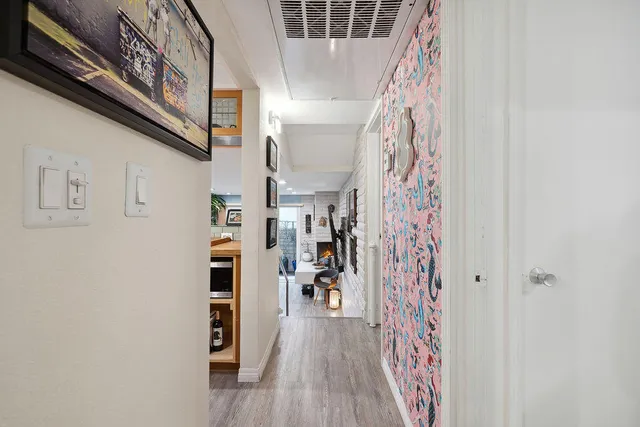 a view of a hallway with wooden floor and entryway
