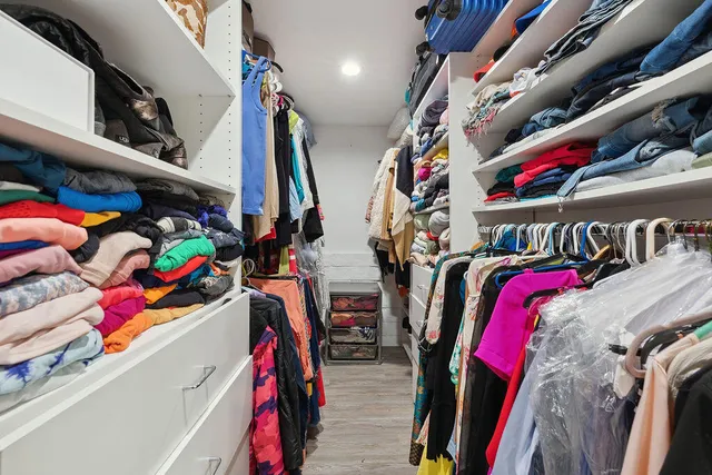 a view of walk in closet with clothes and shoes