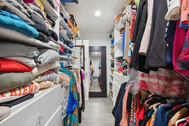 a view of a hallway with wooden floor and closet