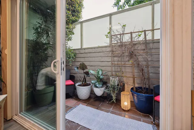a view of a balcony with chair and potted plants