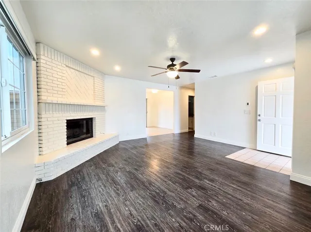 a view of an empty room with a fireplace and a window