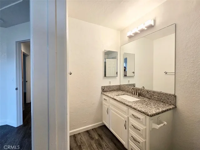 a bathroom with a granite countertop sink and a mirror