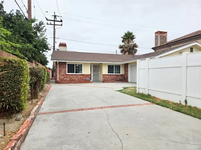 a front view of a house with a yard and potted plants