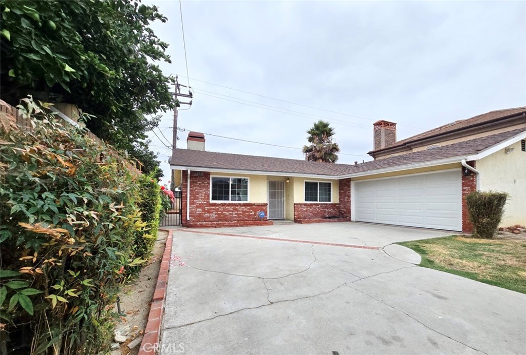 7352 Nada Street Downey, CA 90242 - Photo 3 of 28 a front view of a house with yard and parking