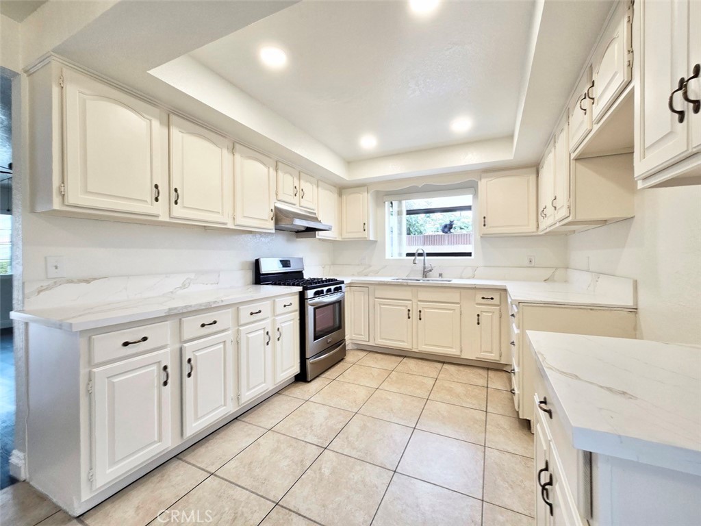 7352 Nada Street Downey, CA 90242 - Photo 4 of 28 a kitchen with granite countertop white cabinets white stainless steel appliances with a sink and dishwasher