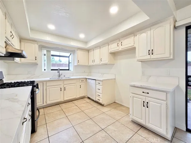 a kitchen with cabinets appliances a sink and a counter top space