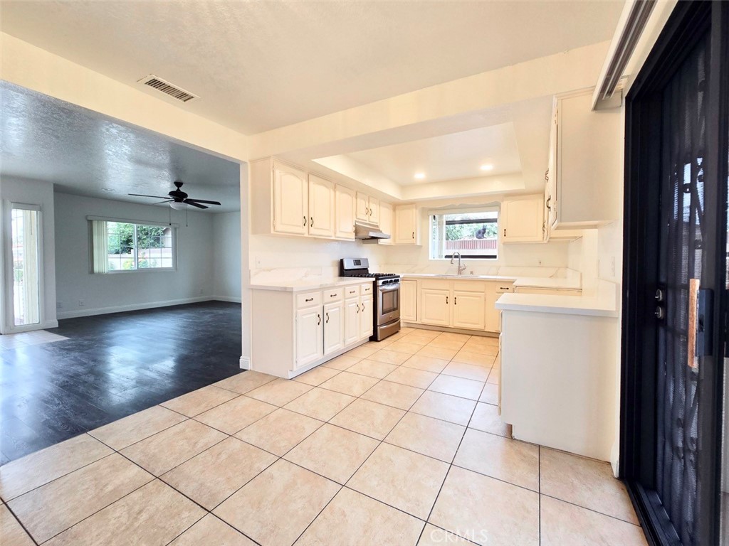7352 Nada Street Downey, CA 90242 - Photo 7 of 28 a large kitchen with a stove a refrigerator and a view of living room