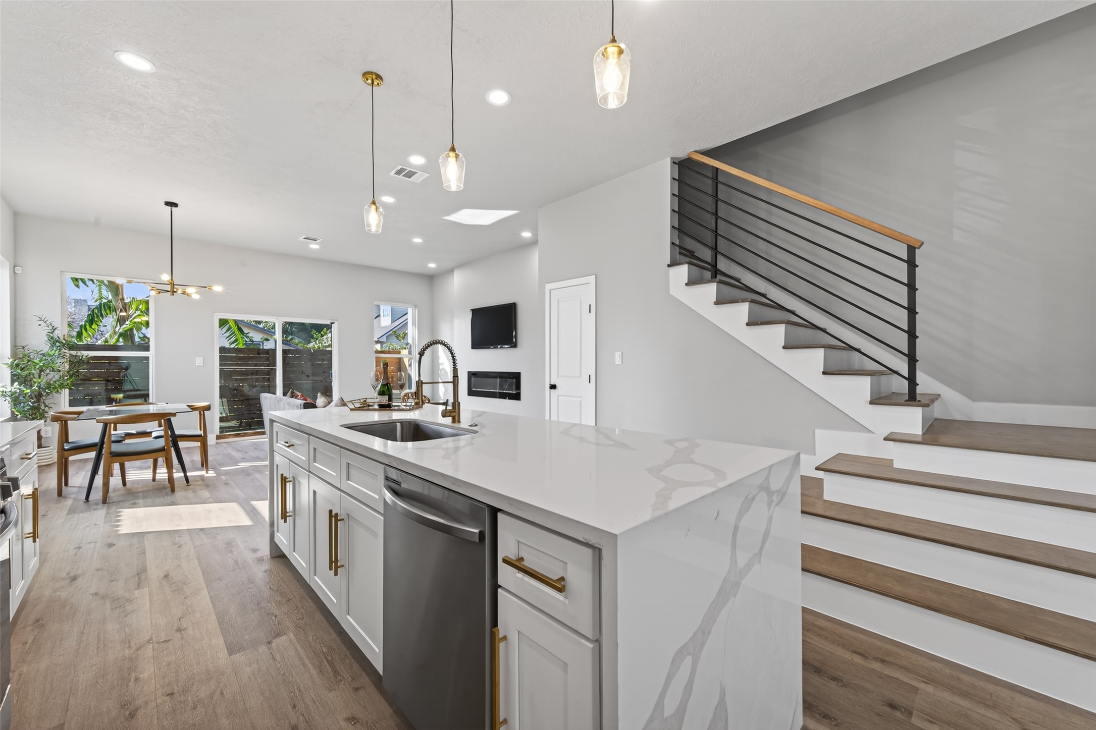 4117 Yale Street Houston, TX 77018 - Photo 11 of 37 a large kitchen with kitchen island a stove a sink a dining table and chairs with wooden floor