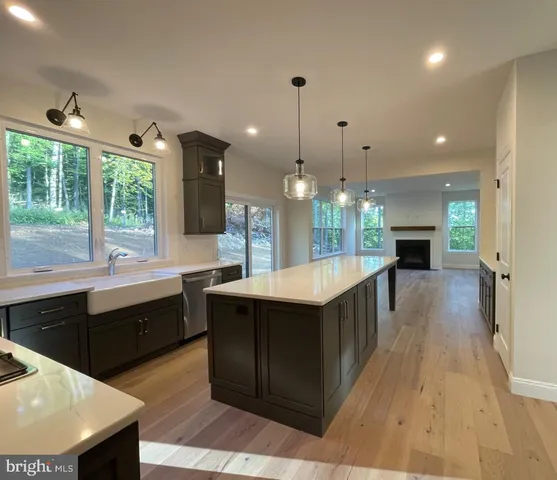a large kitchen with kitchen island a sink appliances counter top space and a large window