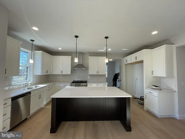 a large kitchen with kitchen island a sink stainless steel appliances and cabinets