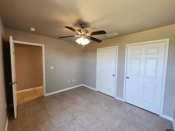 a view of an empty room with a ceiling fan