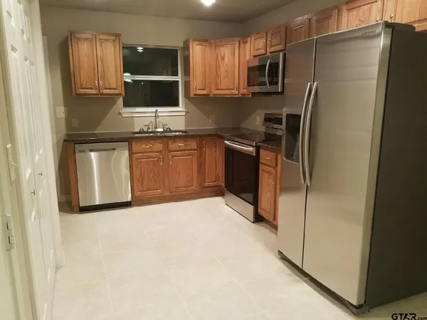 a kitchen with stainless steel appliances granite countertop a refrigerator stove and microwave