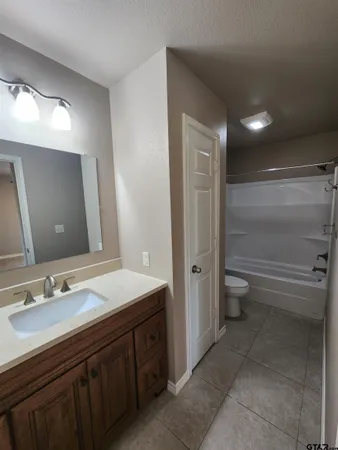 a bathroom with a double vanity sink toilet and a mirror
