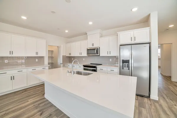 a kitchen with refrigerator cabinets and wooden floor