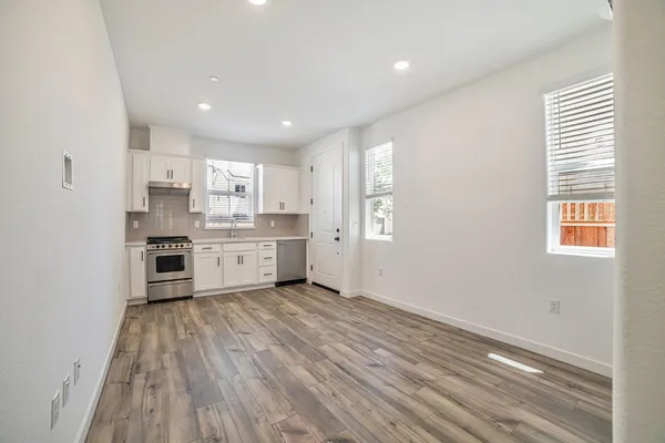a kitchen with stainless steel appliances granite countertop a stove a sink and a refrigerator