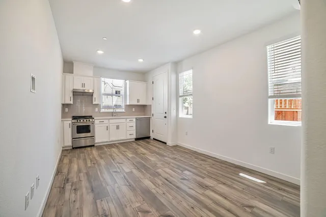 a kitchen with stainless steel appliances granite countertop a stove a sink and a refrigerator