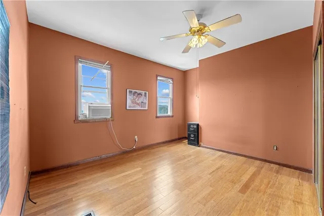 an empty room with a window and a ceiling fan