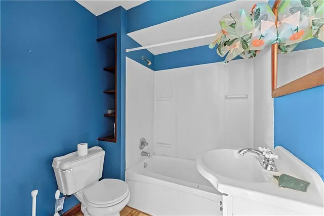 a white toilet sitting next to a bathroom sink and tub