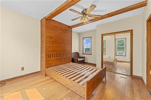 a bedroom with a bed and wooden floor