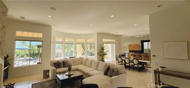 a living room with furniture a fireplace and a floor to ceiling window