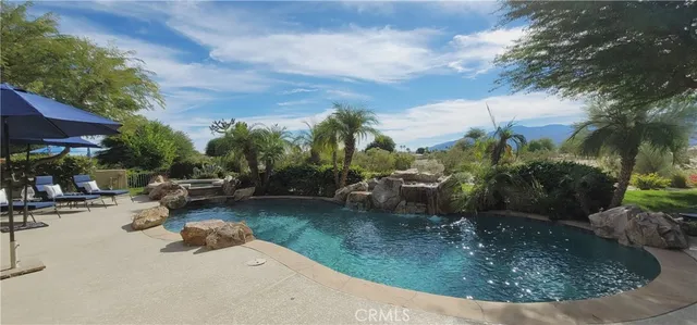 a view of a backyard house with swimming pool and sitting area