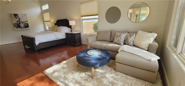 a living room with furniture a flat screen tv and a floor to ceiling window