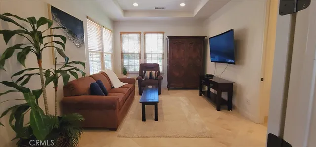 a dining room with wooden floor a chandelier a wooden table and chairs