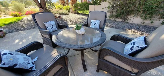 a view of a patio with couple of chairs and a fountain