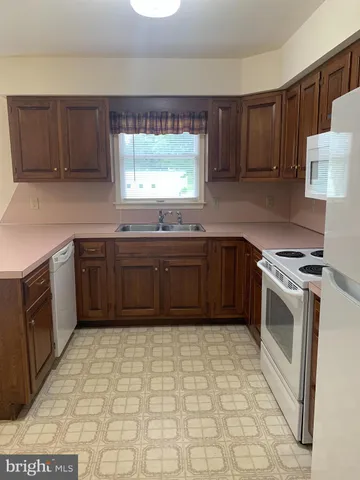 a kitchen with stainless steel appliances granite countertop a sink a stove a refrigerator and cabinets