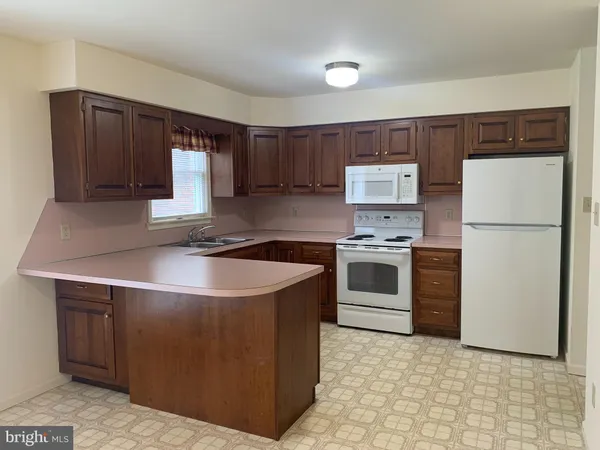 a kitchen with a stove a refrigerator and a sink