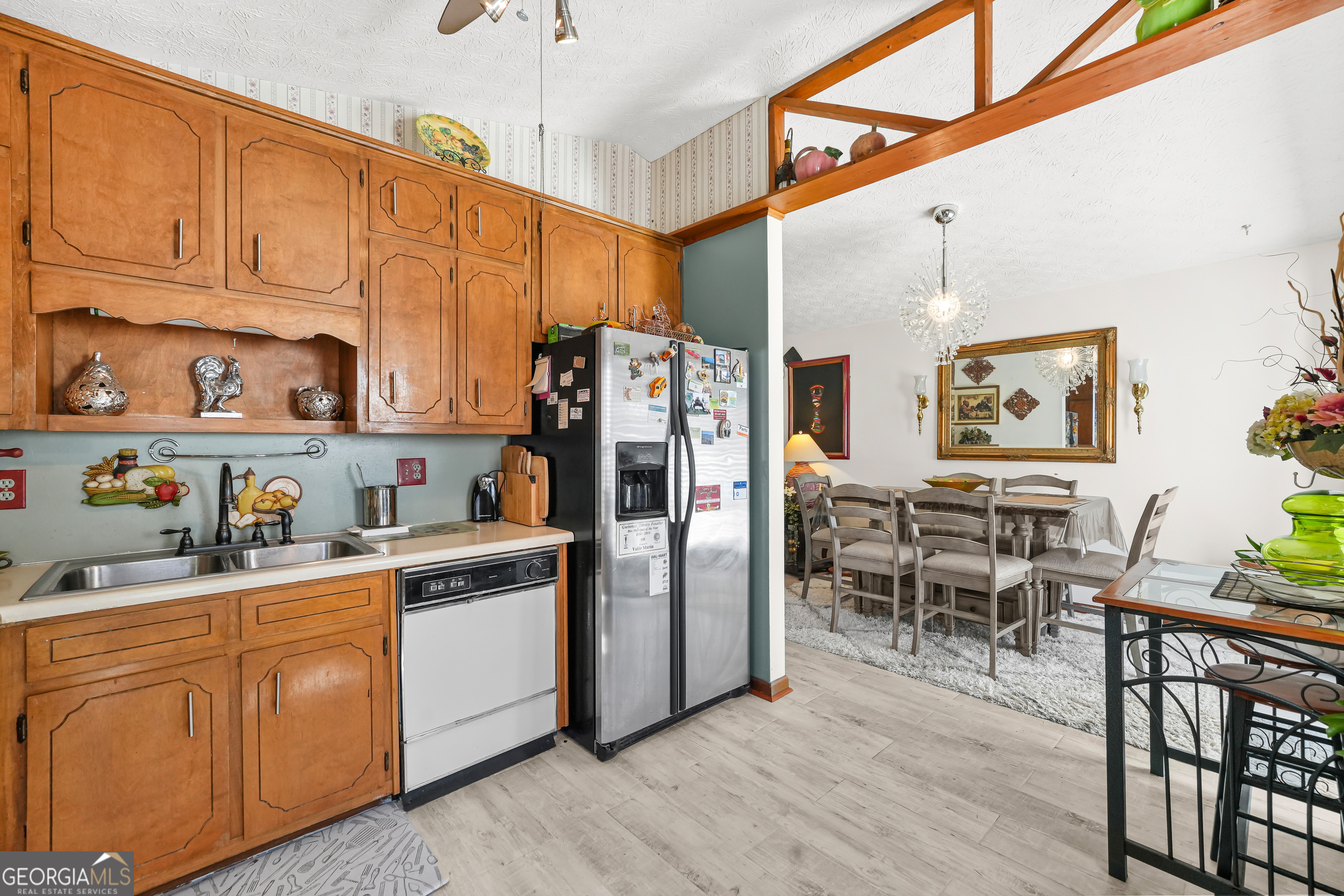 3111 Octavia Lane Snellville, GA 30039 - Photo 15 of 42 a kitchen with stainless steel appliances granite countertop a refrigerator a sink dishwasher a dining table and chairs with wooden floor
