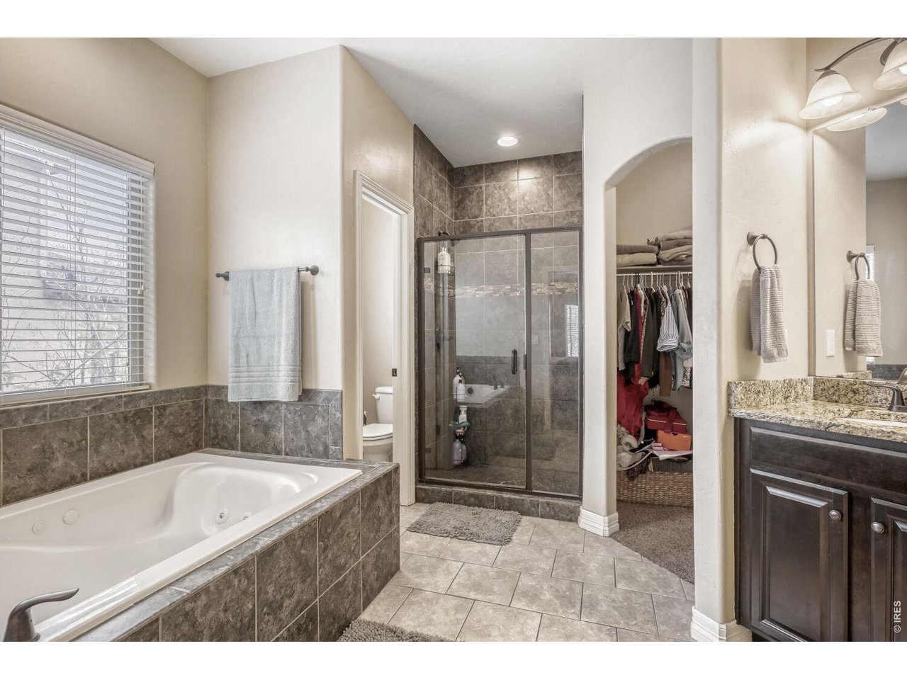 7992 St Street Frederick, CO 80530 - Photo 20 of 28 a bathroom with a granite countertop tub sink shower and mirror