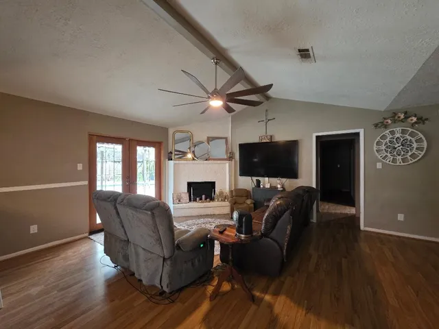 a living room with furniture a flat screen tv and a fireplace