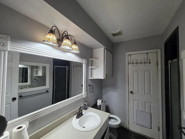 a bathroom with a sink a light fixture and a mirror