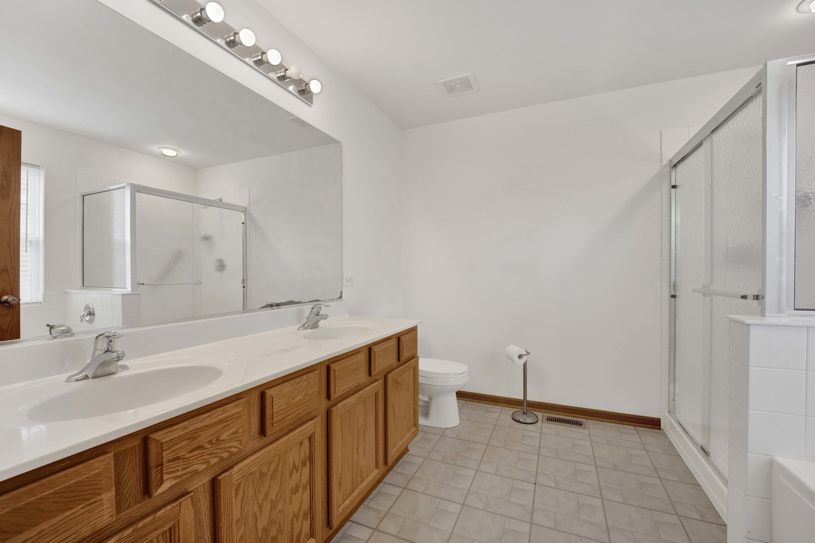 3904 Stockton Drive Joliet, IL 60421 - Photo 22 of 33 a bathroom with a double vanity sink and a mirror