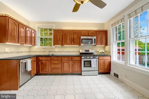 a large kitchen with stainless steel appliances granite countertop a refrigerator and a sink